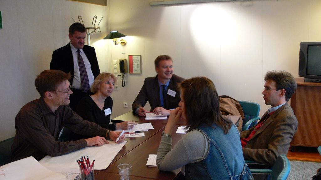 Ryhmäkuva pöydän ääressä istuvista henkilöistä, jotka osallistuivat Konservatorioliiton OPS-peruste-risteilylle vuonna 2006.